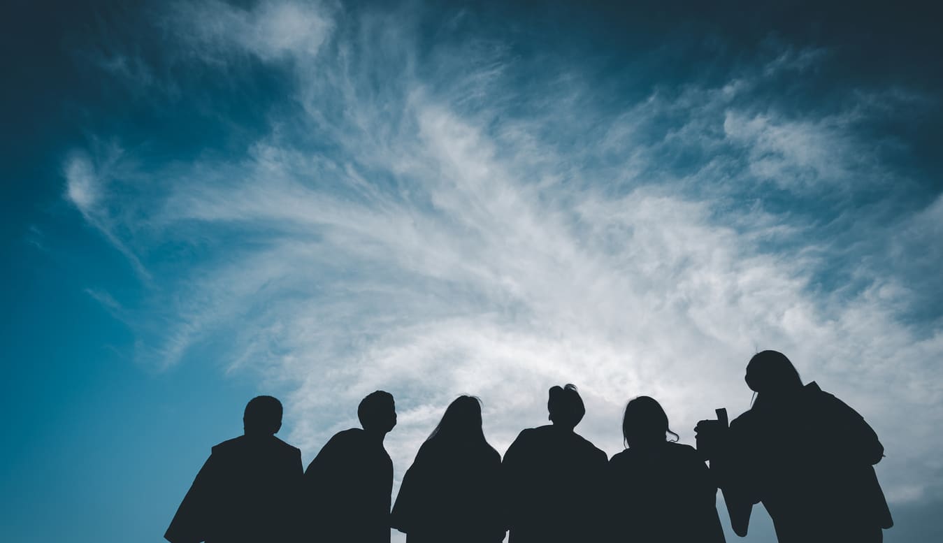 group of people staring at sky with clouds