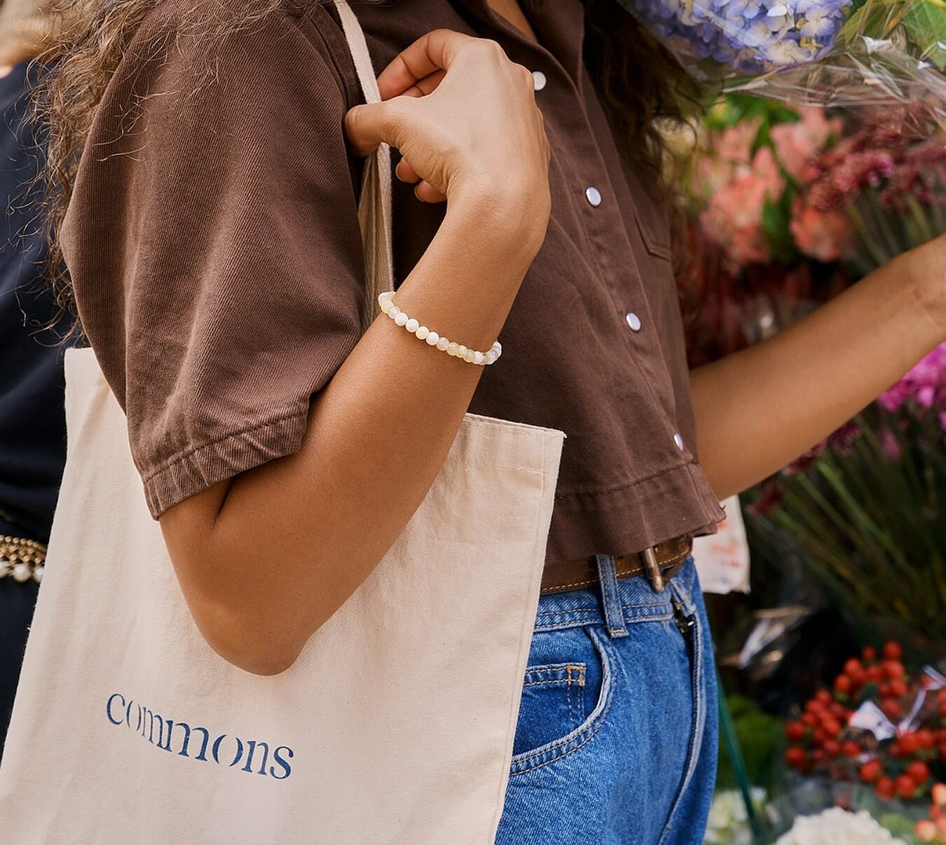 person holding commons tote bag