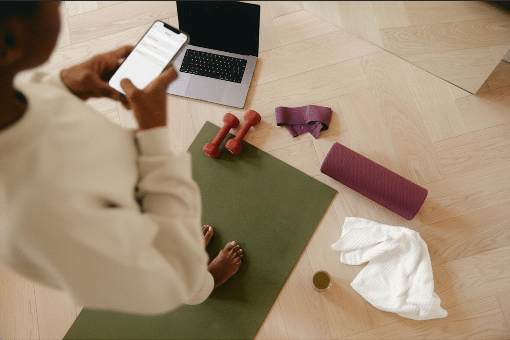 lady standing on yoga mat scrolling on phone