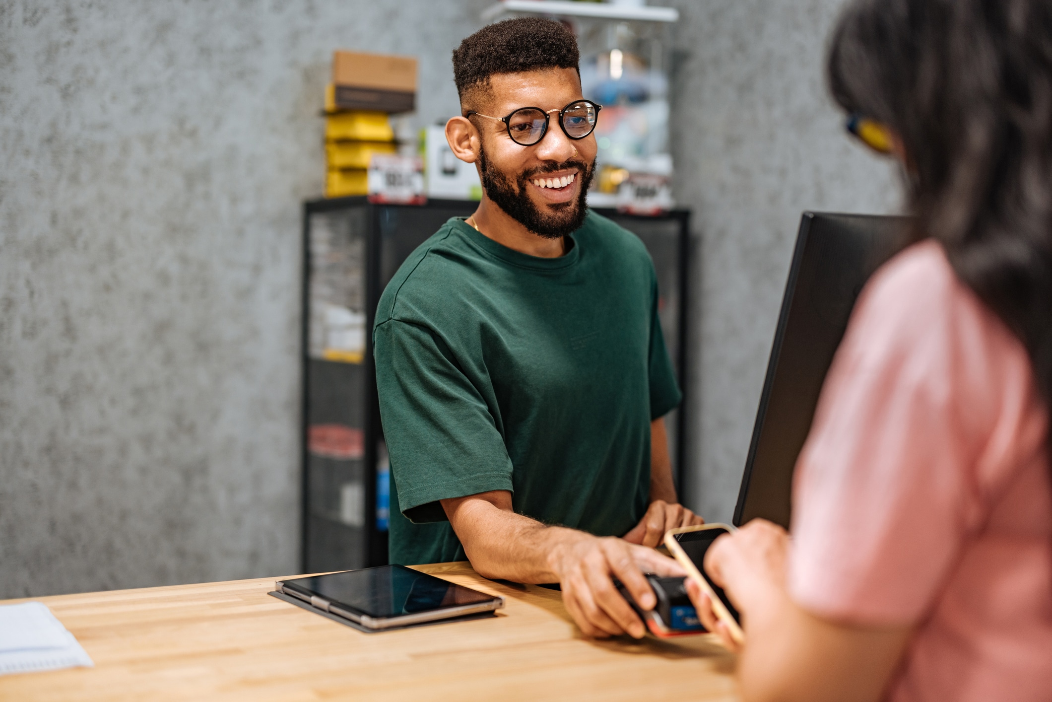 person standing at counter helping customer check out